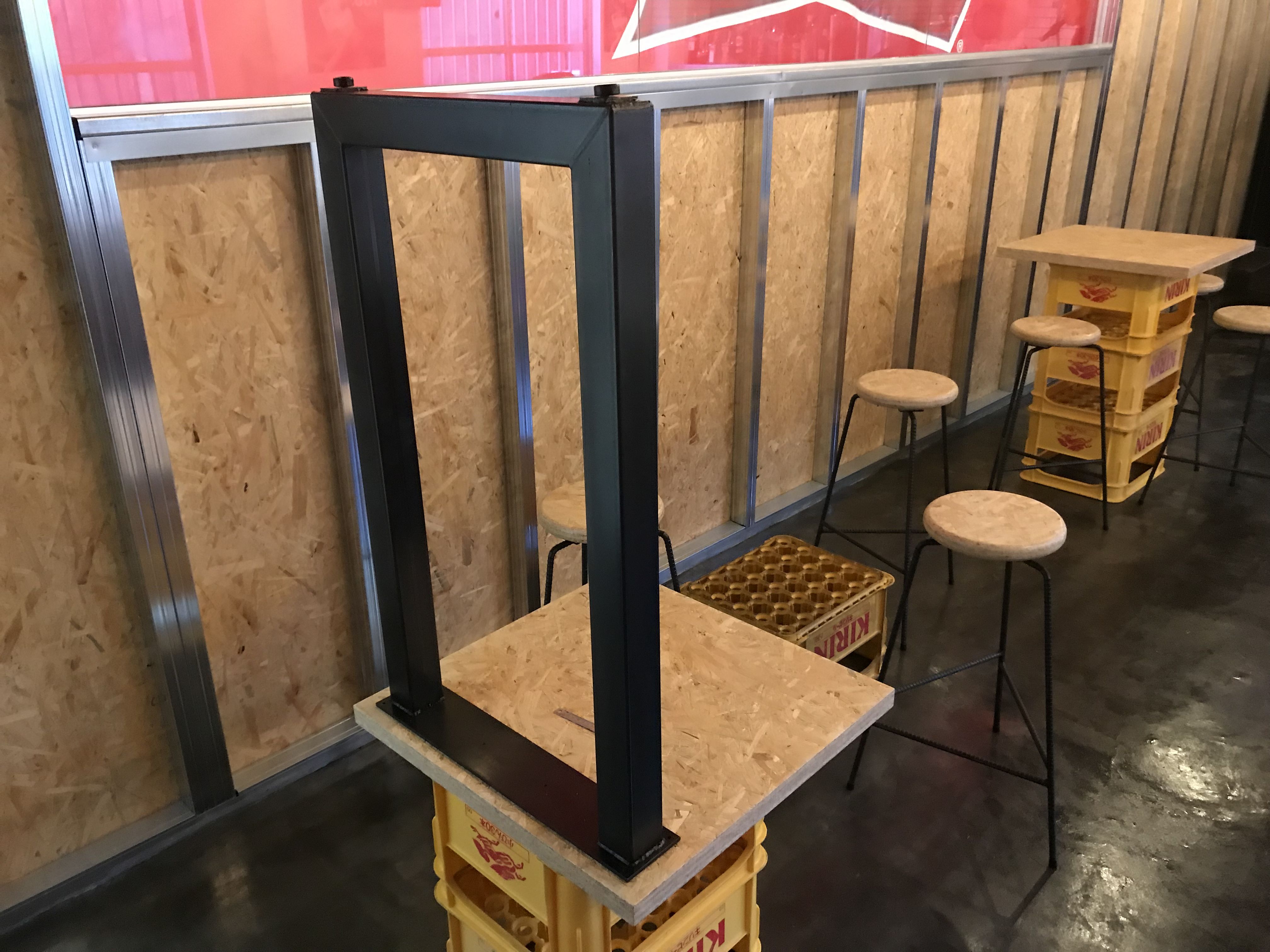 黒皮鉄フレームをOSB合板の天板に取り付け中