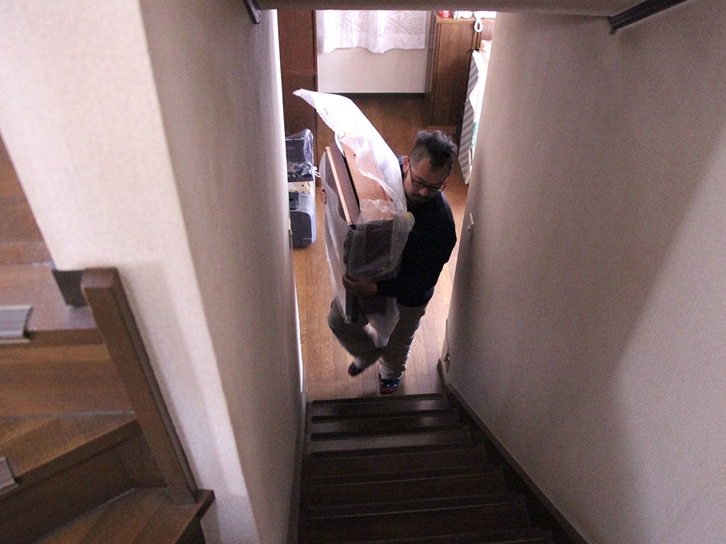 戸建ての2階に家具を納品させていただく様子