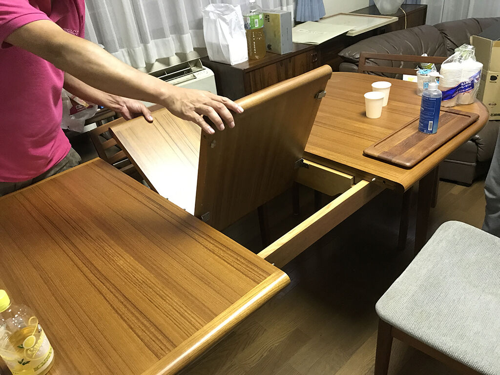 天板をスライドさせて内部から延長用天板を取り出し簡単に伸縮することのできるテーブル