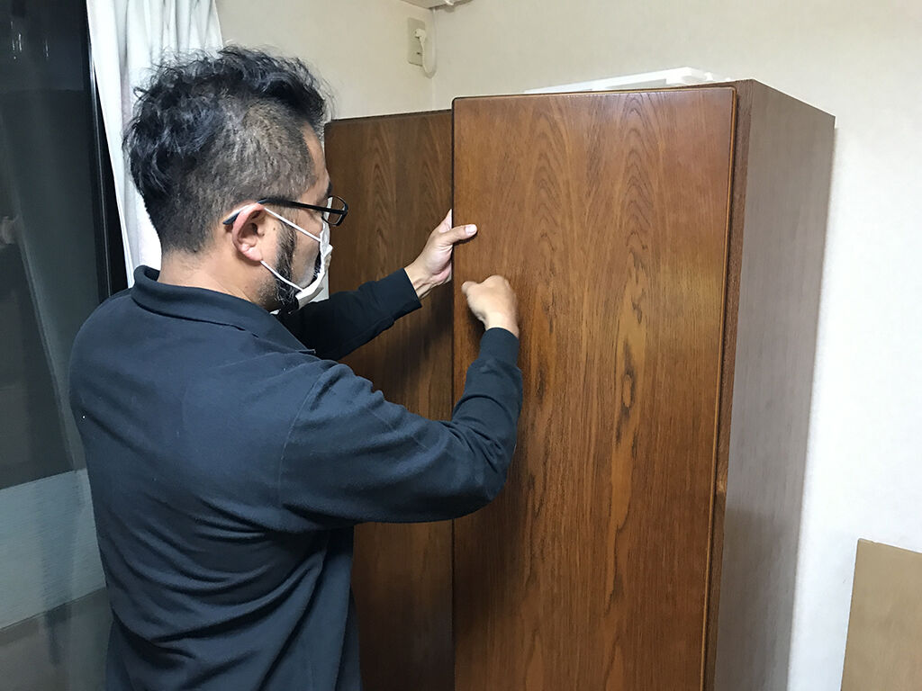 タンスの部材を叩いて造りを推測するルーツファクトリー代表の家具作りたいおっさん