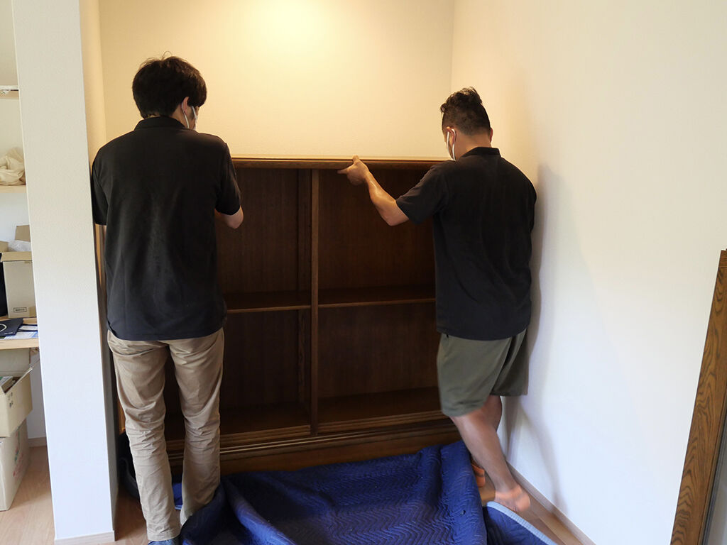 空間にぴったりのため養生布団に家具をのせて移動させながら設置