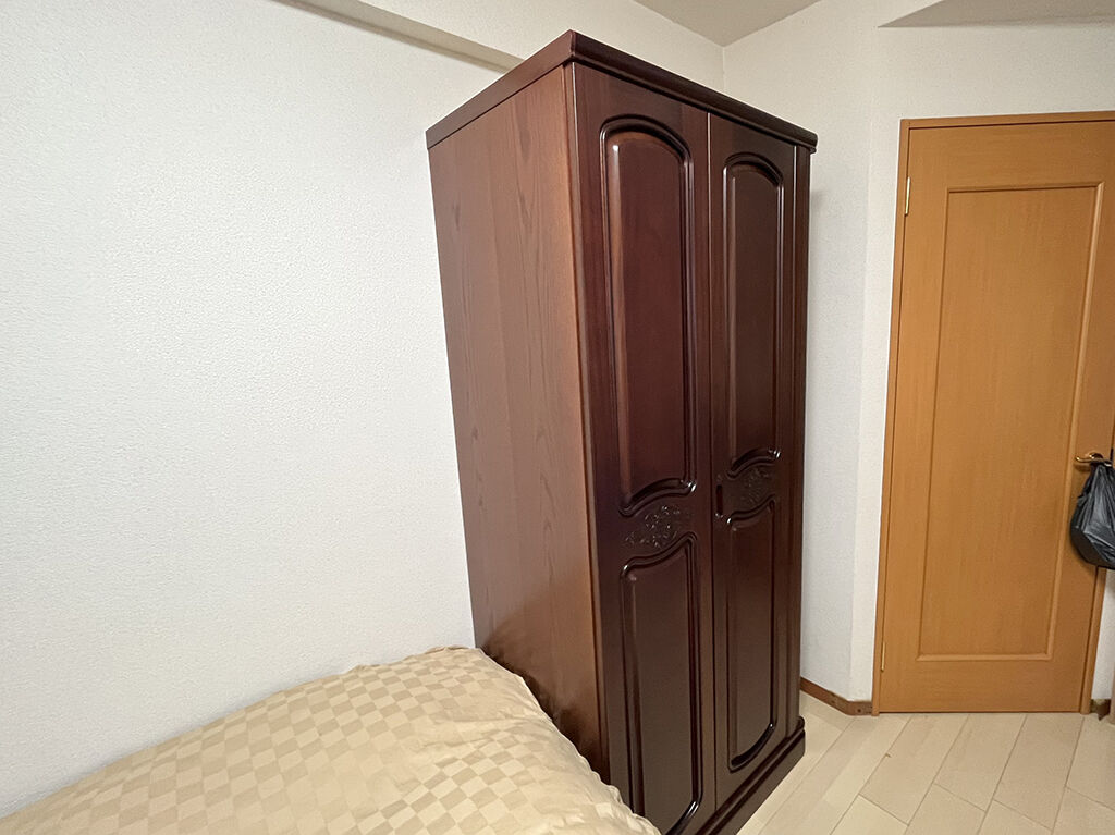 ベッドと壁面の空間にすっぽりと収まったリメイク後の洋服タンス