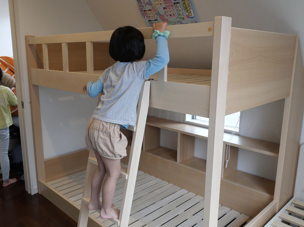 ベッドのはしごを上るお子さん