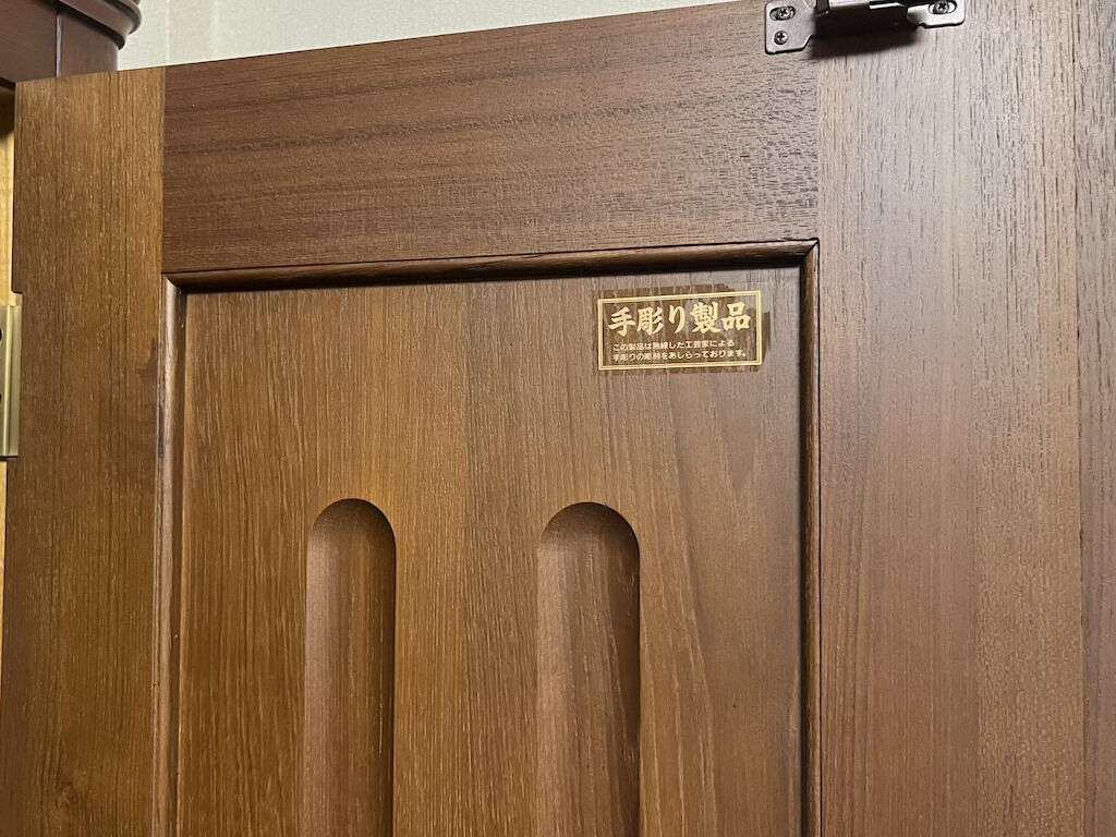 「手彫り製品」とシールが貼られていた婚礼タンスの扉裏側